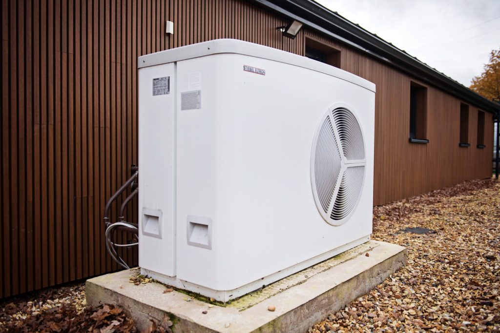 Air source heat pump outside a timber-clad building