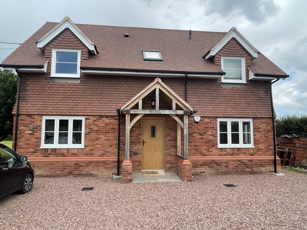Detached brick house with a timber porch