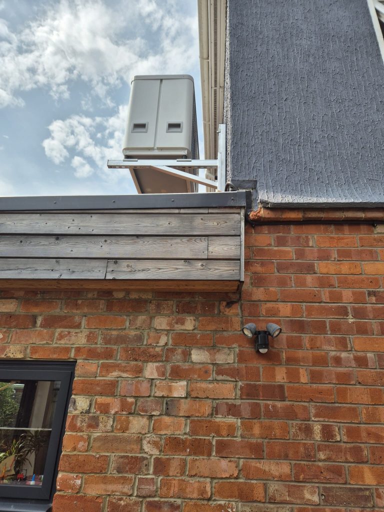 Air source heat pump mounted on a brick wall