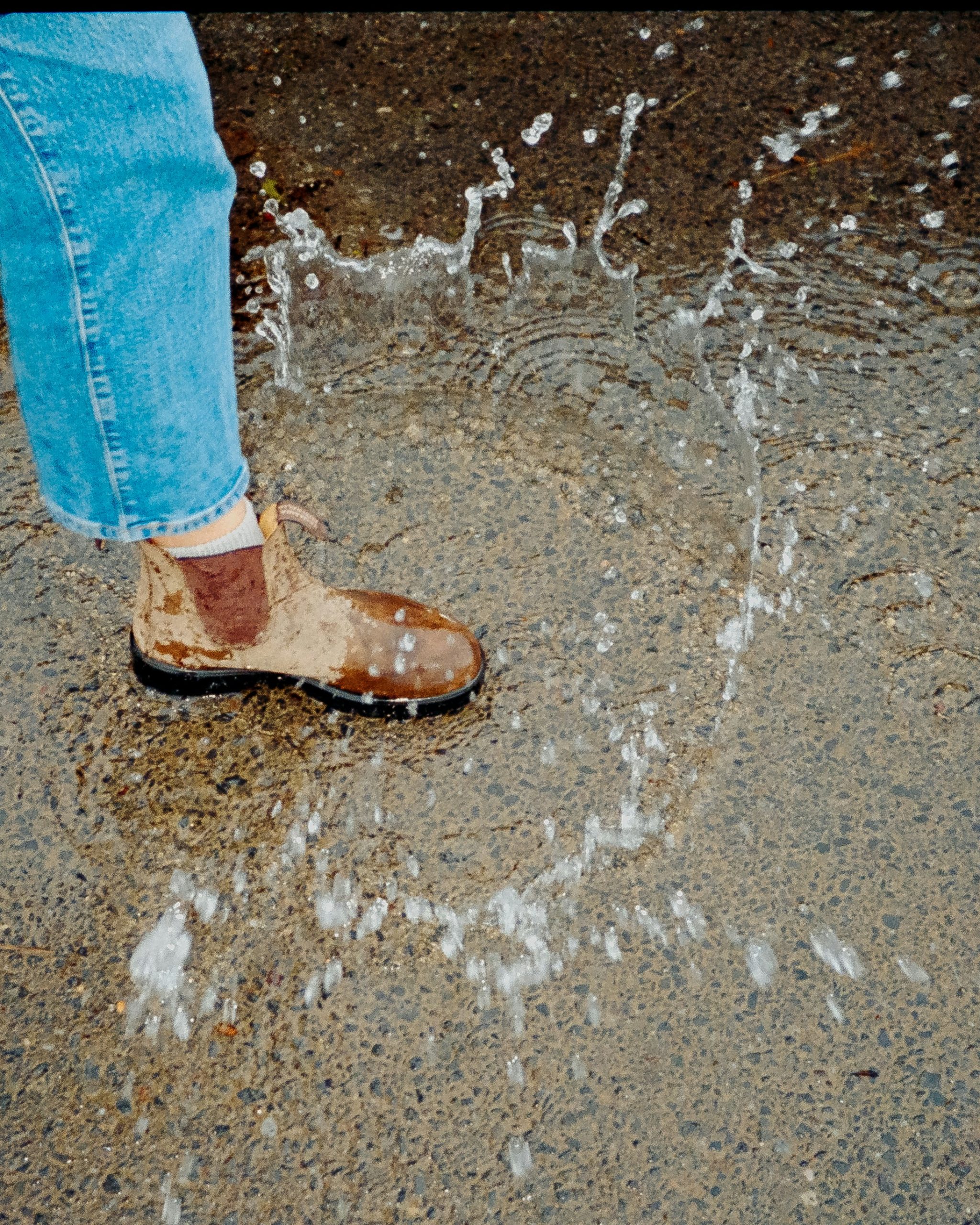 Person in sandals standing in heavy rain
