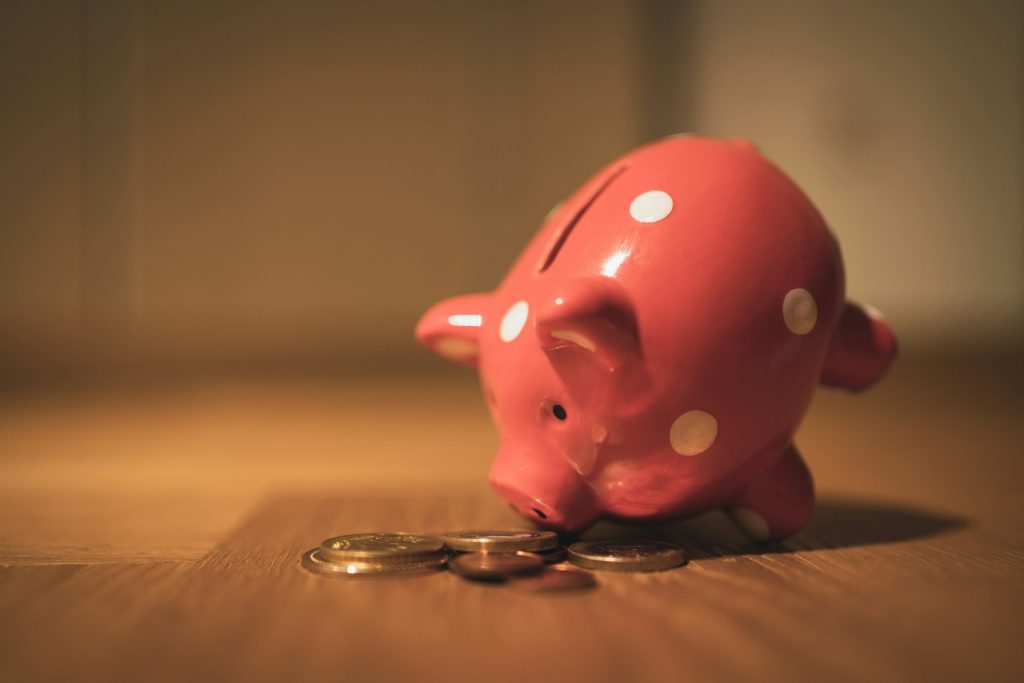 Pink piggy bank with coins, representing savings on energy bills