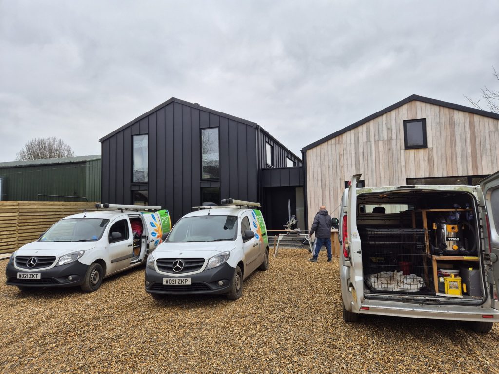 PBT Installations vans outside a black-clad barn conversion
